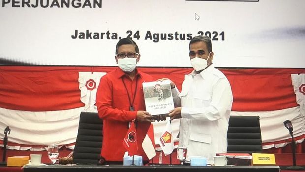 Sekjen PDIP Hasto Kristiyanto menerima cendera mata, berupa buku yang ditulis Prabowo Subianto, dari Sekjen Gerindra Ahmad Muzani, di kantor DPP PDIP, Menteng, Jakarta Pusat, Selasa (24/8/2021).