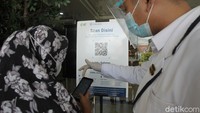 Pengunjung melakukan pemindaian aplikasi Peduli Lindungi saat akan memasuki pusat perbelanjaan Ambarrukmo Plaza, Yogyakarta, Selasa (24/8/2021).