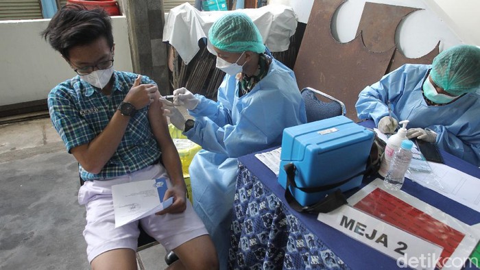 Siswa/i menerima vaksin jenis sinovac saat pelaksanaan vaksinasi massal untuk pelajar di kantor PDAM Tirta Marta, Yogyakarta, Selasa (24/8/2021). Siswa yang sudah divaksin menerima gelang vaksin.