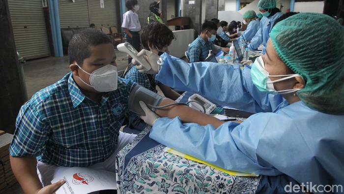 Siswa/i menerima vaksin jenis sinovac saat pelaksanaan vaksinasi massal untuk pelajar di kantor PDAM Tirta Marta, Yogyakarta, Selasa (24/8/2021). Siswa yang sudah divaksin menerima gelang vaksin.