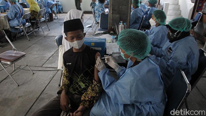 Siswa/i menerima vaksin jenis sinovac saat pelaksanaan vaksinasi massal untuk pelajar di kantor PDAM Tirta Marta, Yogyakarta, Selasa (24/8/2021). Siswa yang sudah divaksin menerima gelang vaksin.