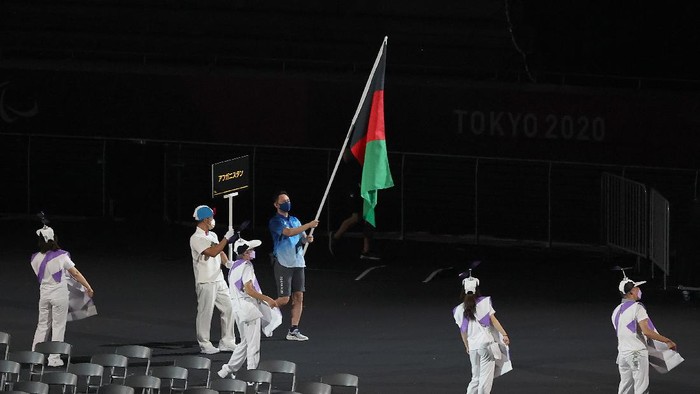 TOKYO, JAPAN - AUGUST 24: A volunteer holds the flag of Afghanistan in the parade of athletes during the opening ceremony of the Tokyo 2020 Paralympic Games at the Olympic Stadium on August 24, 2021 in Tokyo, Japan. (Photo by Alex Pantling/Getty Images)