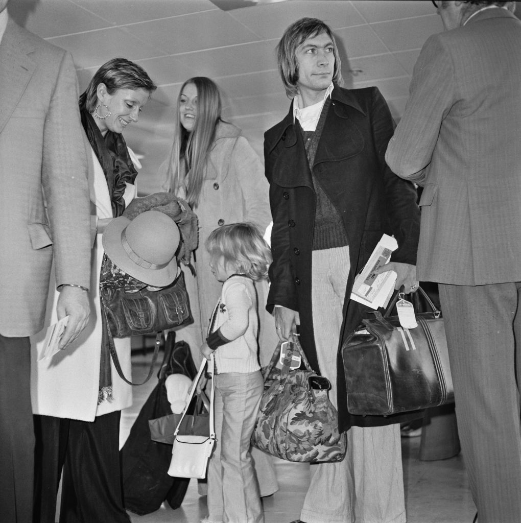 English drummer Charlie Watts of rock group the Rolling Stones at Heathrow Airport in London with his wife Shirley (left) and their daughter Seraphina, UK, 5th December 1972.  (Photo by Evening Standard/Hulton Archive/Getty Images)
