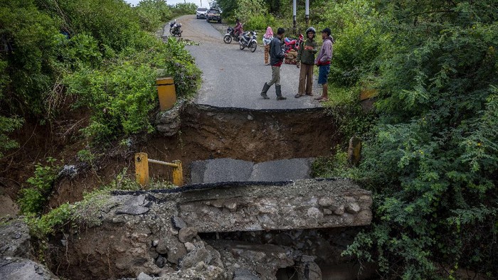 JEMBATAN AMBRUK DIGERUS ARUS SUNGAI Sejumlah warga meratakan tebing sungai untuk membuat jalan alternatif setelah jembatan ambruk digerus arus sungai di Desa Pombewe, Sigi, Sulawesi Tengah, Rabu (25/8/2021). Jembatan yang menghubungkan ruas jalan Palu-Sigi itu ambruk setelah digerus arus air sungai akibat hujan deras di hulu. Tidak ada korban jiwa dalam peristiwa itu namun arus lalulintas terputus dan dialihkan ke jalan alternatif lainnya sejauh lebih dari 20 kilometer. ANTARA FOTO/Basri Marzuki/hp.