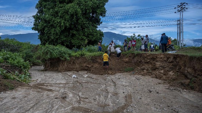 JEMBATAN AMBRUK DIGERUS ARUS SUNGAI Sejumlah warga meratakan tebing sungai untuk membuat jalan alternatif setelah jembatan ambruk digerus arus sungai di Desa Pombewe, Sigi, Sulawesi Tengah, Rabu (25/8/2021). Jembatan yang menghubungkan ruas jalan Palu-Sigi itu ambruk setelah digerus arus air sungai akibat hujan deras di hulu. Tidak ada korban jiwa dalam peristiwa itu namun arus lalulintas terputus dan dialihkan ke jalan alternatif lainnya sejauh lebih dari 20 kilometer. ANTARA FOTO/Basri Marzuki/hp.