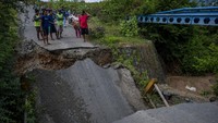 Sejumlah warga memerhatikan jembatan yang ambruk digerus arus sungai di Desa Pombewe, Sigi, Sulawesi Tengah, Rabu (25/8/2021).