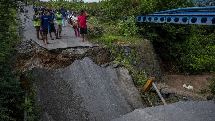 JEMBATAN AMBRUK DIGERUS ARUS SUNGAI Sejumlah warga meratakan tebing sungai untuk membuat jalan alternatif setelah jembatan ambruk digerus arus sungai di Desa Pombewe, Sigi, Sulawesi Tengah, Rabu (25/8/2021). Jembatan yang menghubungkan ruas jalan Palu-Sigi itu ambruk setelah digerus arus air sungai akibat hujan deras di hulu. Tidak ada korban jiwa dalam peristiwa itu namun arus lalulintas terputus dan dialihkan ke jalan alternatif lainnya sejauh lebih dari 20 kilometer. ANTARA FOTO/Basri Marzuki/hp.