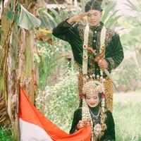 Pengantin wanita yang kini tinggal bersama dengan sang suami Anas di desa Tunjung, Kecamtan Burneh, Kabupaten Bangkalan, Madura itu menuturkan tema foto pernikahannya adalah sambil memegang bendera. Karena bertepatan dengan momen bulan Agustus hari kemerdekaan. Jadi mas Fuad mencari background alam yang natural, ini bukti bahwa kami mengambil momen foto di kebun, terang Ila. Foto: Dok. pribadi Lailatus saodah.