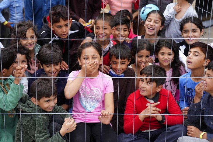 Pengungsi Afghanistan di Jerman A recently evacuated young Afghan girl smiles into the camera at the Ramstein U.S. Air Base, Germany, Tuesday, Aug. 24, 2021. The largest American military community overseas housed thousands of Afghan evacuees in an increasingly crowded tent city. (AP Photo/Matthias Schrader)