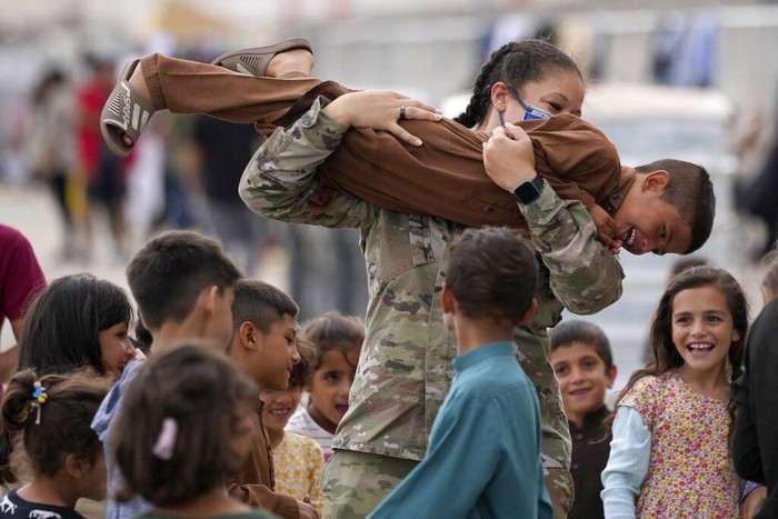 Pengungsi Afghanistan di Jerman A recently evacuated young Afghan girl smiles into the camera at the Ramstein U.S. Air Base, Germany, Tuesday, Aug. 24, 2021. The largest American military community overseas housed thousands of Afghan evacuees in an increasingly crowded tent city. (AP Photo/Matthias Schrader)