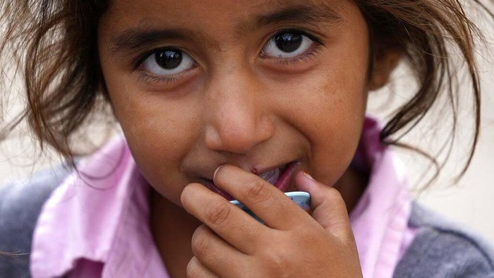 Pengungsi Afghanistan di Jerman A recently evacuated young Afghan girl smiles into the camera at the Ramstein U.S. Air Base, Germany, Tuesday, Aug. 24, 2021. The largest American military community overseas housed thousands of Afghan evacuees in an increasingly crowded tent city. (AP Photo/Matthias Schrader)