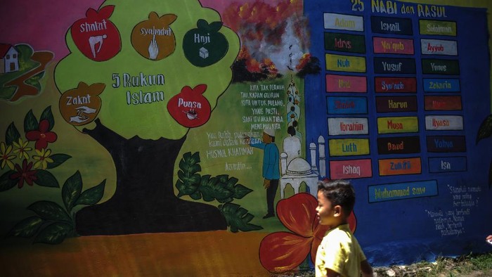 KAMPUNG MURAL RELIGI DI KABUPATEN BANDUNG Sejumlah anak bermain di samping dinding yang dihiasi mural bertema keagamaan di Kampung Kukun Endah, Desa Cikoneng, Kabupaten Bandung, Jawa Barat, Kamis (26/1/2021). Warga berinisiatif untuk menghias dinding dengan tema keagaaman guna memberikan edukasi pada anak tentang ilmu keagamaan serta menjaga dinding dari coretan vandalisme. ANTARA FOTO/Raisan Al Farisi/rwa.
