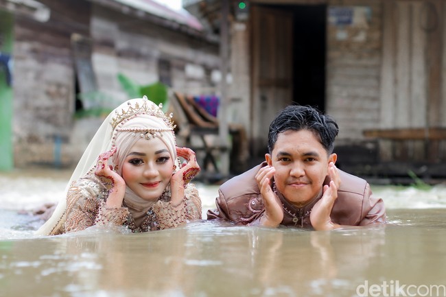 Wolipop sudah menghubungi Muhammad Hasbi sebagai fotografer dan yang mengunggah video tersebut ke TikTok. Ia mengatakan jika video yang viral tentang pengantin sesi foto pernikahan di tengah banjir itu diambil pada Minggu (15/8/2021) di daerah Jembatan Patah, Desa Kintapura, Kecamatan Kintap, Kabupaten Tanah Laut, Provinsi Kalimantan Selatan. Foto: Dok/@manday_presto.