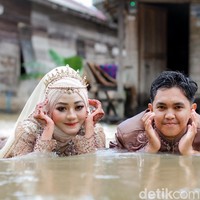 Wolipop sudah menghubungi Muhammad Hasbi sebagai fotografer dan yang mengunggah video tersebut ke TikTok. Ia mengatakan jika video yang viral tentang pengantin sesi foto pernikahan di tengah banjir itu diambil pada Minggu (15/8/2021) di daerah Jembatan Patah, Desa Kintapura, Kecamatan Kintap, Kabupaten Tanah Laut, Provinsi Kalimantan Selatan. Foto: Dok/@manday_presto.