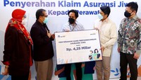 Direktur AXA Mandiri Uke Giri Utama menyaksikan penyerahan secara secara simbolis klaim untuk tenaga kesehatan dari perwakilan keluarga perawat, yang disaksikan juga oleh Ketua Umum DPP Persatuan Perawat Nasional Indonesia (PPNI) Harif Fadillah, di Jakarta, Kamis (26/8/2021).