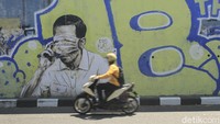 Gambar mirip Jokowi dengan mata tertutup masker di Jalan Prabu Dimuntur, Kota Bandung, Kamis (26/8/2021). Yudha Maulana/detikcom
