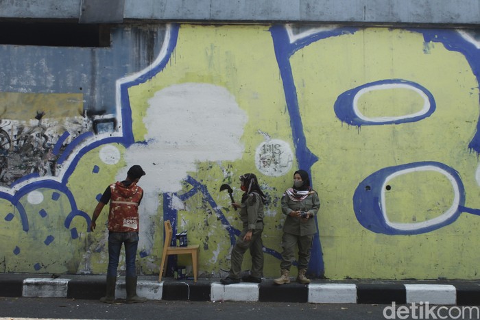 Sejumlah petugas tengah membersihkan sisa mural pria mirip Jokowi di Bandung. Sejumlah petugas tengah membersihkan sisa mural pria mirip Jokowi di Bandung.