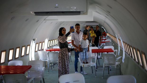 A Boeing 707 aircraft has been converted to a cafe, in Wadi Al-Badhan, just outside the West Bank city of Nablus, Aug. 11, 2021. Few Palestinians in the occupied West Bank get to board an airplane these days. The territory has no civilian airport and those who can afford a plane ticket must catch their flights in neighboring Jordan. But twins brothers, Khamis al-Sairafi and Ata, are offering people the old airplane for customers to board. (AP Photo/Majdi Mohammed)
