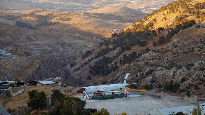 A Boeing 707 aircraft has been converted to a cafe, in Wadi Al-Badhan, just outside the West Bank city of Nablus, Aug. 11, 2021. Few Palestinians in the occupied West Bank get to board an airplane these days. The territory has no civilian airport and those who can afford a plane ticket must catch their flights in neighboring Jordan. But twins brothers, Khamis al-Sairafi and Ata, are offering people the old airplane for customers to board. (AP Photo/Majdi Mohammed)