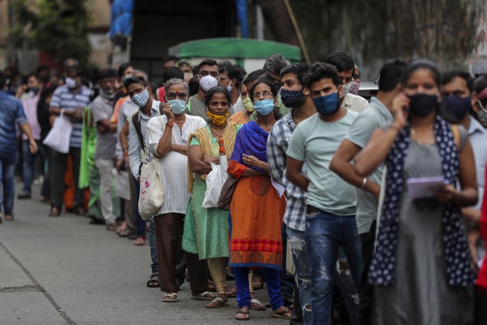 India Disebut Masuki Masa Endemi People wait to get inoculated against COVID-19 at a vaccination center in Mumbai, India, Tuesday, Aug. 17, 2021. (AP Photo/Rafiq Maqbool)