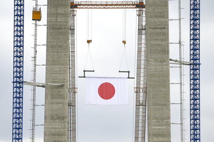 Jembatan Gantung Terpanjang di Rumania Workers install cables on the structure during a ceremony marking 100 years of diplomatic relations between Japan and Romania, at the construction site of a suspension bridge over the Danube river in Braila, Romania, Thursday, Aug. 26, 2021. The bridge, built by Japanese and Italian companies, with a span of 1,974.3 meters, will be the largest of its kind in Romania and the third in the European union.(AP Photo/Vadim Ghirda)