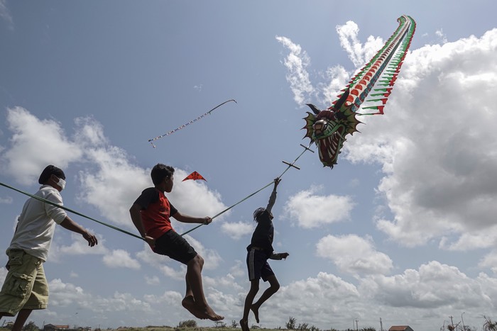 Anggota Komunitas Pelayang Cilacap menaiki layang-layang tıga dimensi yang diterbangkan di Pantai Lengkong, Cilacap Utara, Cilacap, Jateng, Jumat (27/8/2021). Komunitas Pelayang Cilacap rutin menerbangkan layang-layang dua dan tiga dimensi dengan panjang 30-70 meter yang mampu mengangkat beban hingga 50 kg untuk menguji kualitas layang-layang buatan mereka dan menghibur warga sekitar Pantai Cilacap. ANTARA FOTO/Idhad Zakaria/rwa.