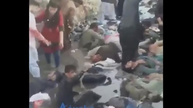 In this image from video, onlookers and injured people surround the site of a deadly explosion outside the airport in Kabul, Afghanistan, Thursday, Aug. 26, 2021. Two suicide bombers and gunmen have targeted crowds massing near the Kabul airport, in the waning days of a massive airlift that has drawn thousands of people seeking to flee the Taliban takeover of Afghanistan. (Aśvaka News Agency via AP)