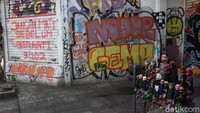 Mural bernada kritikan muncul di Jalan Braga, Kota Bandung, Jawa Barat. Mural tersebut terpasang di rolling door pertokoan. Wisma Putra/detikcom
