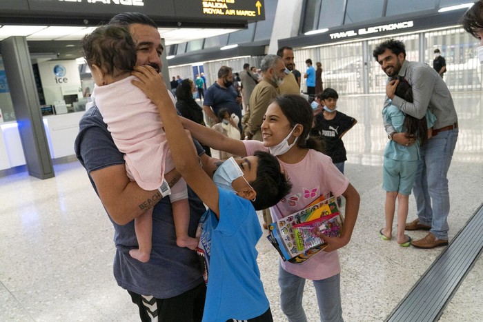 Pengungsi Afghanistan Afghan people who were transported from Afghanistan, walk after disembarking a plane, at the Torrejon military base as part of the evacuation process in Madrid, Monday. Aug. 23, 2021. (AP Photo/Andrea Comas)