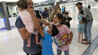 Mahmud menggendong anaknya usai mendarat di bandara Washington Dulles, Virginia, AS (21/8). Pejabat Gedung Putih menyatakan sekitar 7.500 orang dievakuasi dari Kabul dalam waktu 12 jam pada Kamis (26/8) waktu setempat. Mereka diterbangkan dengan menggunakan 14 penerbangan militer AS yang membawa sekitar 5.100 orang dan 39 penerbangan koalisi yang membawa 2.400 orang. (AP Photo/Jose Luis Magana)