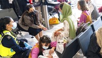 Mendagri Inggris,  Priti Patel (kedua kiri) berbincang dengan pengungsi Afghanistan seusai mendarat di Bandara Heathrow, London (26/8). Menurut pejabat Gedung Putih, AS, lebih dari 100.000 orang telah dievakuasi dari Afghanistan ke sejumlah negara sejak Sabtu (14/8). (Dominic Lipinski/Pool via AP)