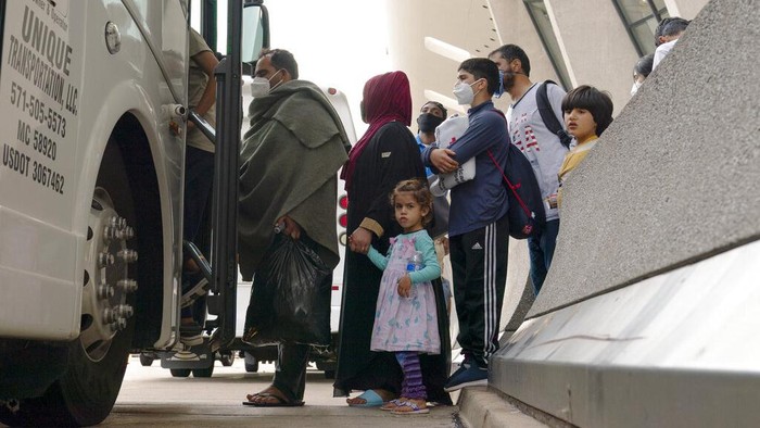 Afghan people who were transported from Afghanistan, walk after disembarking a plane, at the Torrejon military base as part of the evacuation process in Madrid, Monday. Aug. 23, 2021. (AP Photo/Andrea Comas)