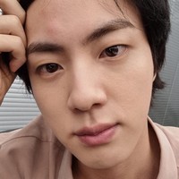 Pada Juli 2021, salah satu personel yang membagikan foto BTS tanpa makeup adalah Jin. Jin BTS berpose selfie saat tak sengaja menjedotkan kepala ke jendela hingga bengkak dan memerah. Visual grup BTS itu tetap terlihat tampan tanpa makeup. Foto: dok Weverse BTS
