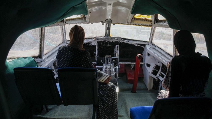 Wow! Ada Kafe Pesawat di Tepi Barat Palestinians visit the cockpit of a Boeing 707 after the plane was converted to a cafe restaurant, in Wadi Al-Badhan, near the West Bank city of Nablus, Wednesday, Aug. 11, 2021. The Palestinian territory has no civilian airport and those who can afford a plane ticket must catch their flights in neighboring Jordan. After a quarter century of effort, twins brothers, Khamis al-Sairafi and Ata, opened the βPalestinian-Jordanian Airline Restaurant and Coffee Shop al-Sairafiβ on July 21, 2021, offering people an old airplane for customers to board. (AP Photo/Majdi Mohammed)