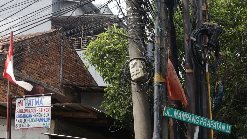 Galian manhole di sepanjang Jl Mampang Prapatan Raya telah selesai digarap. Namun, kabel-kabel yang masih menggantung di tiang belum juga diturunkan.