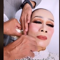 Kemudian masuk ke proses yang bikin netizen terheran-heran. Rangga memperlihatkan cara dia memasang lakban di wajah sang nenek. Bernada guyon, Rangga menyebut proses tersebut sebagai oplas ringan tanpa bahan pengawet. Dari rahang, lakban ditarik di balik kuping. Proses penarikan wajah dengan lakban ini sukses membuat wajah sang nenek jadi lebih kencang. Hasilnya, wajah nenek tampak manglingi. Foto: dok. TikTok/@ranggajuans
