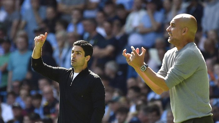Arsenals manager Mikel Arteta, left, and Manchester Citys head coach Pep Guardiola gesture during the English Premier League soccer match between Manchester City and Arsenal at Etihad stadium in Manchester, England, Saturday, Aug. 28, 2021. (AP Photo/Rui Vieira)
