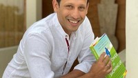 Nadiem Makarim tampak berfoto dengan senyum lebar sembari memegang buku di tangan kanannya. Membaca adalah suatu hal yang sangat penting dan sering saya lakukan agar saya selalu belajar, tulisnya. (Foto: Instagram @nadiemmakarim)