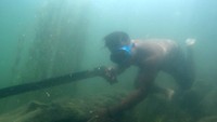 Pekerjaan memanah ikan tersebut dilakukan sejumlah nelayan di tepian danau.
