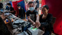Perekaman sidik jari dilakukan dengan bantuan petugas.