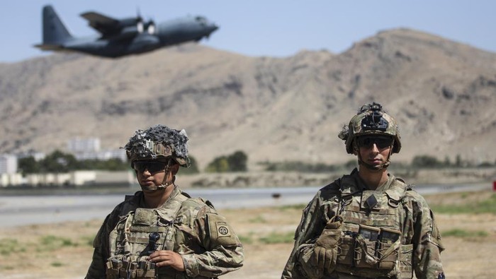 In this image provided by the Department of Defense, two paratroopers assigned to the 1st Brigade Combat Team, 82nd Airborne Division conduct security while a C-130 Hercules takes off during a evacuation operation in Kabul, Afghanistan, Wednesday, Aug. 25, 2021. (Department of Defense via AP)