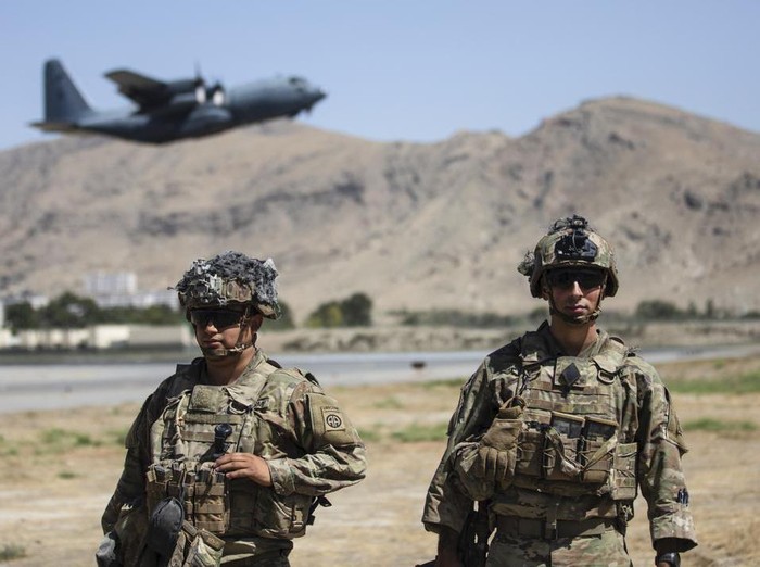 In this image provided by the Department of Defense, two paratroopers assigned to the 1st Brigade Combat Team, 82nd Airborne Division conduct security while a C-130 Hercules takes off during a evacuation operation in Kabul, Afghanistan, Wednesday, Aug. 25, 2021. (Department of Defense via AP)