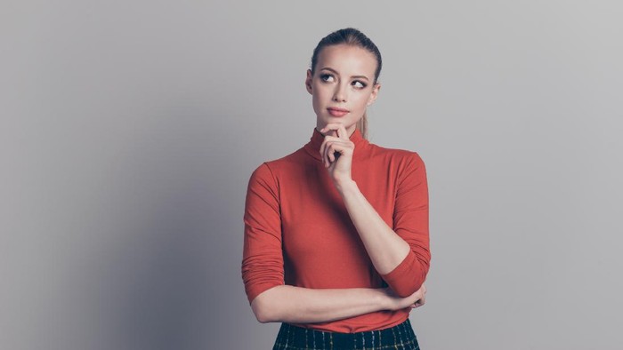 Portrait of her she nice-looking pretty attractive winsome lovely genius girl wearing red sweater touching chin fancy people isolated over gray pastel background.