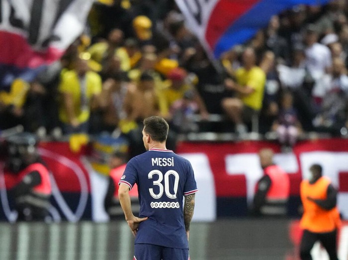 Reims' Marshall Munetsi, left, challenges for the ball with PSG's Lionel Messi during the France League One soccer match between Reims and Paris Saint-Germain, at the Stade Auguste-Delaune in Reims, France, Sunday, Aug. 29, 2021. (AP Photo/Francois Mori)