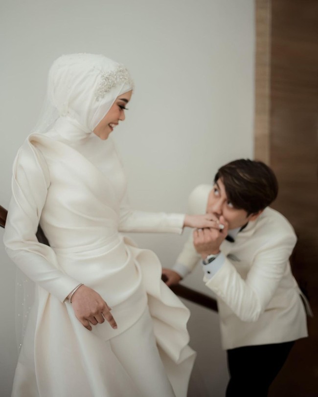 Salah satu busana yang dikenakannya adalah gaun putih rancangan Hian Tjen. Dalam postingannya di Instagram, desainer tersebut menjelaskan desain dari baju yang membuat Lesti tampak bak ratu itu. Foto: Instagram @hiantjen