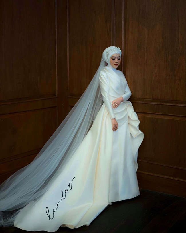 Dan pengantinnya memakai sebuah dress pernikahan tertutup yang cantik dengan sentuhan struktur modern dari hand-draped kasar ciri khas Hian Tjen dan bagian pinggang yang menyatu dengan rok dan juntaian, Foto: Instagram @hiantjen