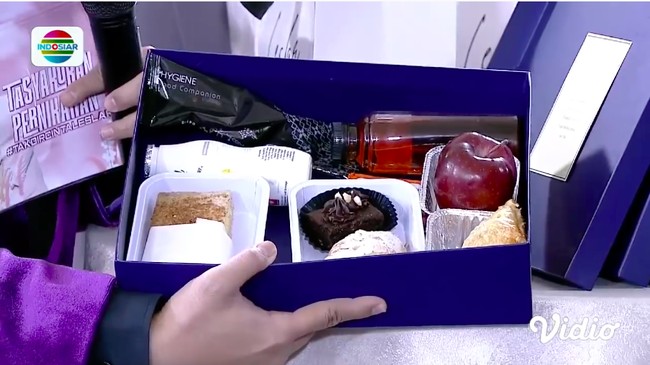 Suvenir disertai dengan dua boks besar yang berisi makanan. Maklum, tak ada prasmanan untuk tamu agar sesuai protokol kesehatan. Boks pertama berisi berbagai jenis pastry, apel, dan minuman segar.(Foto: YouTube/Indosiar)