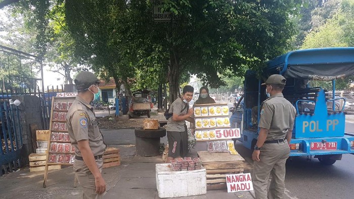 Satpol PP patroli di Jl Raya Bogor. Menertibkan pedagang di trotoar Pasar Induk Kramat Jati, Jakarta Timur, Senin (30/8).