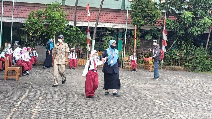 Sekolah tatap muka di SDN 15 Pagi Cengkareng Barat, orang tua siswa mengantarkan anaknya.