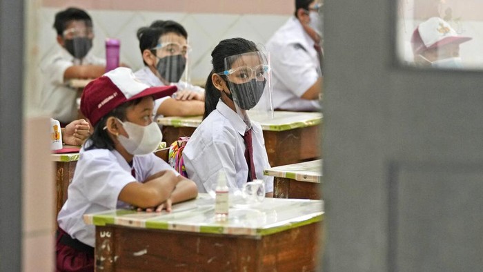 Students wearing face masks to prevent the spread of COVID-19 wash their hands before entering a school building on the first day its reopening in Jakarta, Indonesia, Monday, Aug. 30, 2021. Authorities in Indonesias capital kicked off the school reopening after over a year of remote learning on Monday as the daily count of new COVID-19 cases continues to decline. (AP Photo/Dita Alangkara)